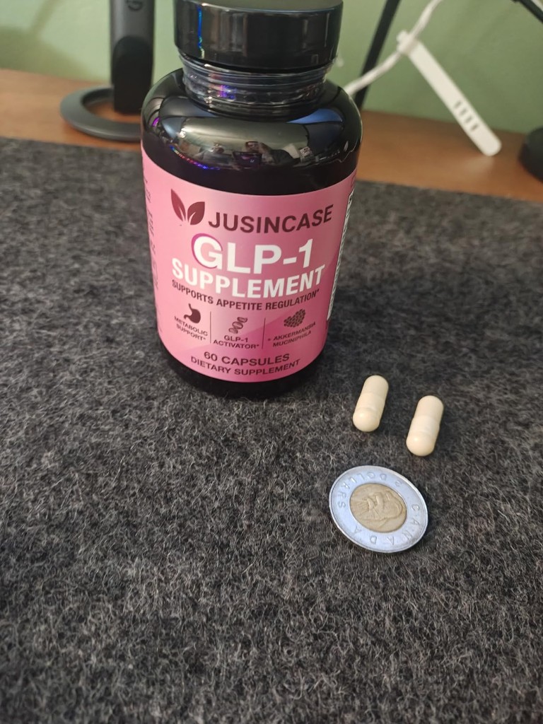 JUSINCASE GLP-1 Supplement bottle with two capsules and a coin for size comparison